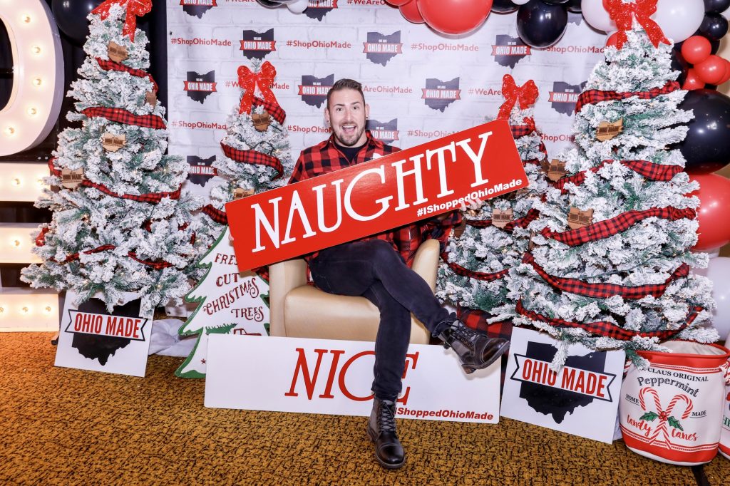 Justin Poole in front of the Ohio Made step and repeat holding the "Naught" sign.